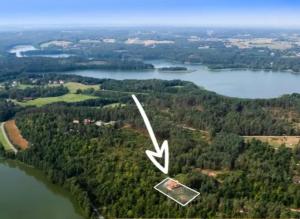 an aerial view of a lake with a house at Leśny Dworek Podjazy in Podjazdy