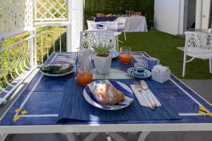 維耶特里的住宿－Al Chiaro di Luna Luxury Suites AMALFI COAST，一张蓝色和白色的桌子,上面有盘子的食物