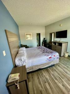 a hotel room with a bed and a television at Delux Inn Cleburne in Cleburne