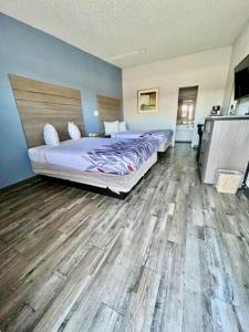 1 dormitorio con 2 camas y suelo de madera en Delux Inn Cleburne, en Cleburne