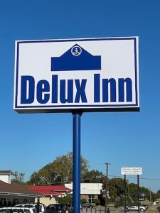 una señal para Delius inn en un estacionamiento en Delux Inn Cleburne, en Cleburne