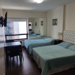 Habitación con 4 camas, escritorio y ventana. en Corrientes y Esmeralda en Buenos Aires