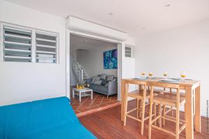 a living room with a table and a blue couch at Duplex de Malendure in Bouillante