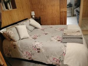 Self Catering apartment Achill Island Pets Allowed في ويستبورت: سرير مع بطانية رمادية عليها ورد