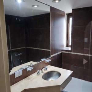 a bathroom with a sink and a large mirror at Corrientes y Esmeralda in Buenos Aires