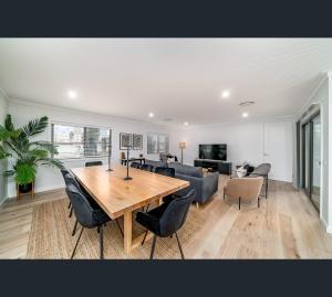 a dining room and living room with a table and chairs at Brand New Luxury Abode on Shaw in Wagga Wagga