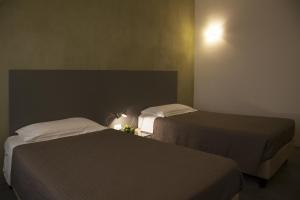 two beds in a small room with at Rosalmar B&B in Palermo