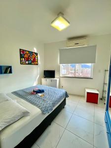 um quarto com uma cama e uma janela em Fioravante's Apartment no Rio de Janeiro