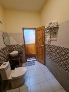 a bathroom with a toilet and a sink at anavrin in Jibhi