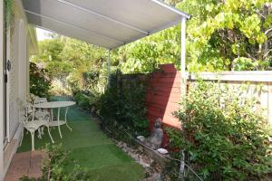 patio con tavolo e ombrellone bianco di Howie's Place Noosa a Noosaville Altre 6 foto
