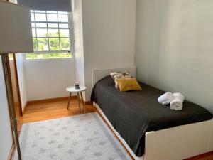 a small bedroom with a bed and a window at Retiro das Bananeiras in Horta