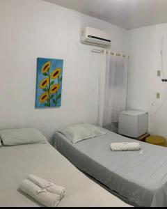 ein Schlafzimmer mit 2 Betten und einem Wandgemälde in der Unterkunft Pousada Aconchego in Aracaju