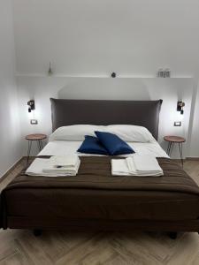 a bedroom with a large bed with blue pillows at Dimora Dei Decumani in Naples