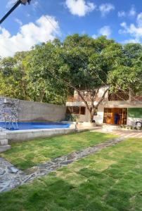 a house with a tree in the middle of a yard at Cabaña Casa Lila in Santa Marta