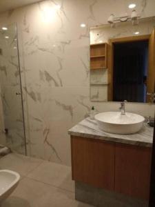 a bathroom with a sink and a glass shower at Appartement Les bienvenus in Essaouira