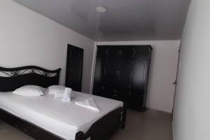 a bedroom with a bed and a black cabinet at Casa hotel Armenia in Armenia +1 photo