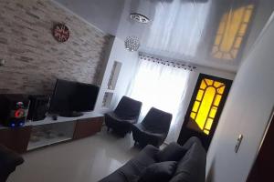 a living room with a couch and chairs and a tv at Casa hotel Armenia in Armenia