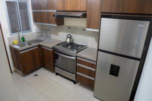 a small kitchen with a stove and a refrigerator at Casa Pinatar en condominio in Santa Cruz de la Sierra