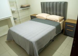 a bedroom with a bed with a gray headboard at Casa Pinatar en condominio in Santa Cruz de la Sierra