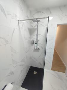 y baño con ducha y paredes de mármol blanco. en VUT La Villa, en Vilagarcía de Arousa