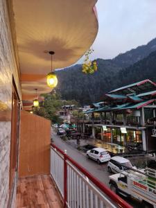 a balcony with a view of a street with cars at anavrin in Jibhi