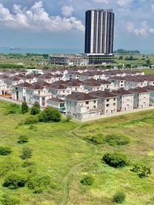 a group of houses in a field with a tall building at Atlantis Residence Melaka ForMuslims Homestay in Melaka