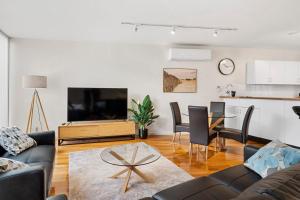 un salon avec un canapé et une télévision dans l'établissement Centre Stage - Stroll to the Waterfront, à Hobart