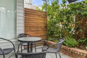 une table et des chaises sur une terrasse avec une clôture dans l'établissement Centre Stage - Stroll to the Waterfront, à Hobart