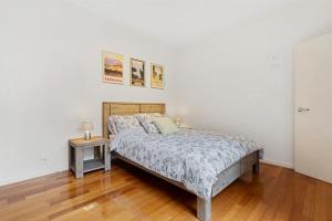 une chambre avec un lit et un parquet dans l'établissement Centre Stage - Stroll to the Waterfront, à Hobart