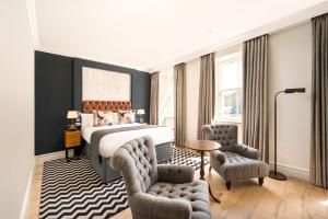 1 dormitorio con 1 cama y 2 sillas en Hotel Indigo - Edinburgh - Princes Street, an IHG Hotel en Edimburgo