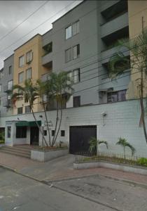 un edificio en una calle con palmeras delante en Mejor ubicación en cali, en Cali