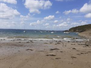 a sandy beach with boats in the water at Mobilhome Vue mer et nature in Plougastel-Daoulas