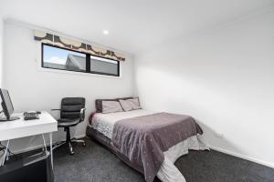 - une chambre avec un lit, un bureau et un ordinateur dans l'établissement Mellow Yellow, à Taupo