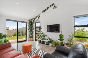 a living room with a couch and some plants at Mellow Yellow in Taupo