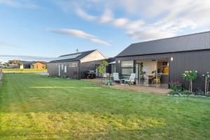 une maison noire avec une cour devant elle dans l'établissement Mellow Yellow, à Taupo