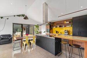 a kitchen with a dining table and yellow cabinets at Mellow Yellow in Taupo