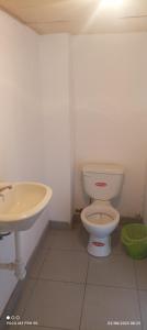 a bathroom with a toilet and a sink at Rufino y Lucrecia MUNAY TIKA WASI Posada Oha in Puno