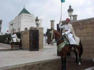un hombre montando un caballo con una bandera en él en House City Center, en Rabat