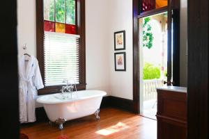 een badkamer met een wit bad en een raam bij Summit Street Inns in Winston-Salem