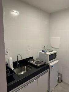 a kitchen with a sink and a microwave at Sudoeste, sua busca termina aqui, Lindo apt na Clsw 103 in Brasilia