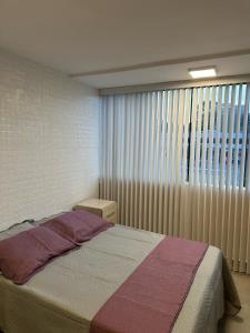 Un dormitorio con una cama y una ventana grande. en Lindo Apt de 1 quarto no Sudoeste 103, próximo do centro de convenções Ulysses Guimarães, mane garrincha e ministérios, en Brasilia