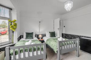 1 dormitorio con 2 camas individuales y ventana en Lparking Sleep7 4br 2 Ba, en Horsford