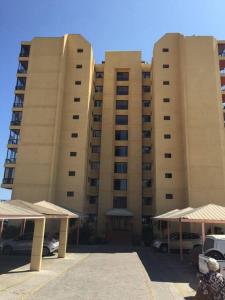 two tall buildings with cars parked in front of them at Gran departamento frente a la bahía de La Herradura in Coquimbo