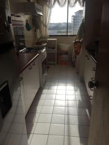 een keuken met een witte tegelvloer en een raam bij Gran departamento frente a la bahía de La Herradura in Coquimbo