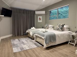 a bedroom with two beds and a television in it at Serene Place Guest House & Conference Venue AFFORDABLE LUXURY WITH BACKUP POWER in Roodepoort +23 photos