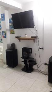 Habitación con escritorio y TV en la pared. en Casa Amplia Completa Privada para Familias en Santa Marta