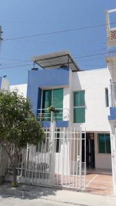 una casa azul y blanca con una valla blanca en Casa Amplia Completa Privada para Familias, en Santa Marta