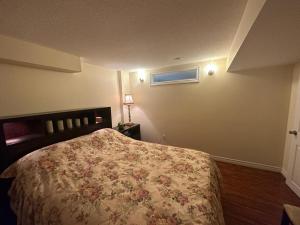 a bedroom with a bed with a floral bedspread at Basement apartment in Richmond Hill