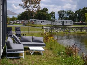 un par de sillas y una mesa junto a un río en Brand new chalet on a completely new luxury resort, 