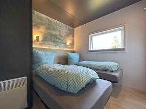 a bedroom with two beds and a window at FERIENDORF SEEBLICK in Bavaria - tiny chalets with terrace right on the lake in Neunburg vorm Wald